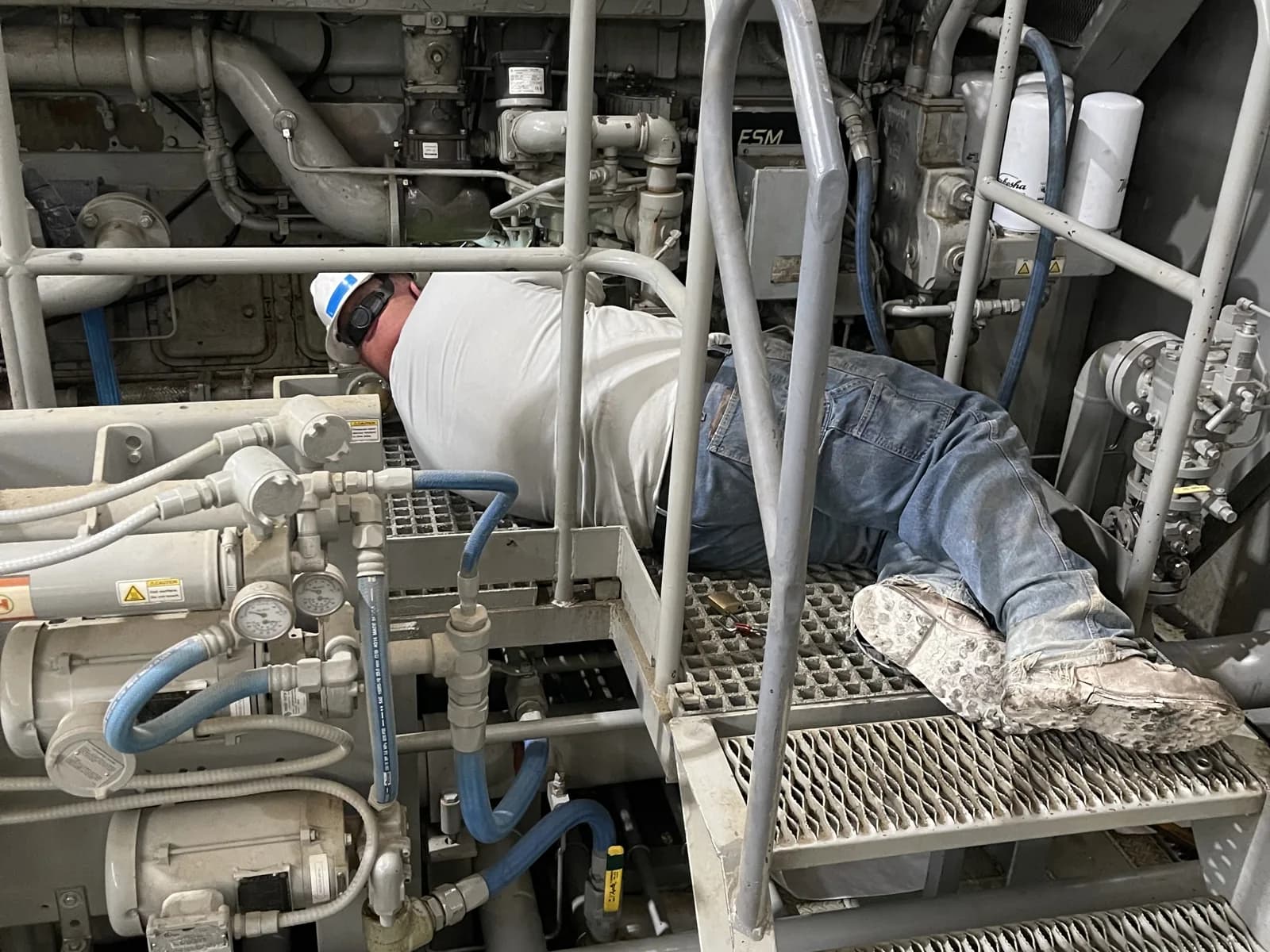 ShalePro compressor operator inspecting a unit for leaks