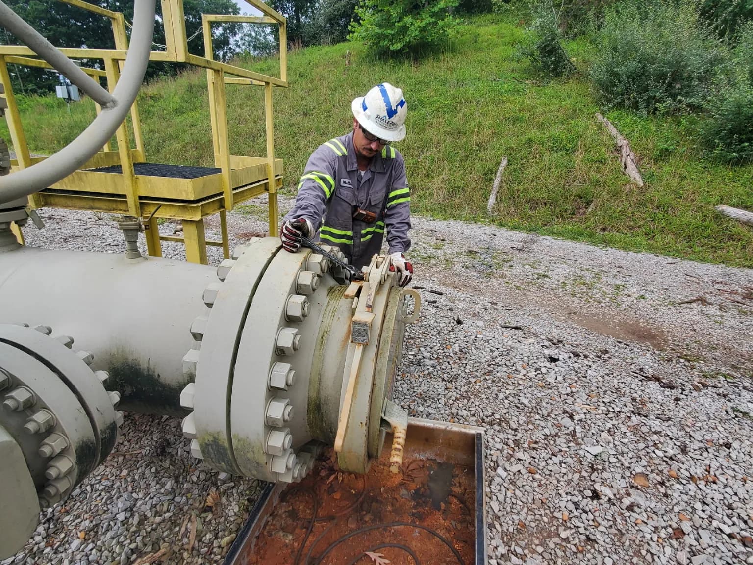 ShalePro pipeline technician preparing a pig receiver