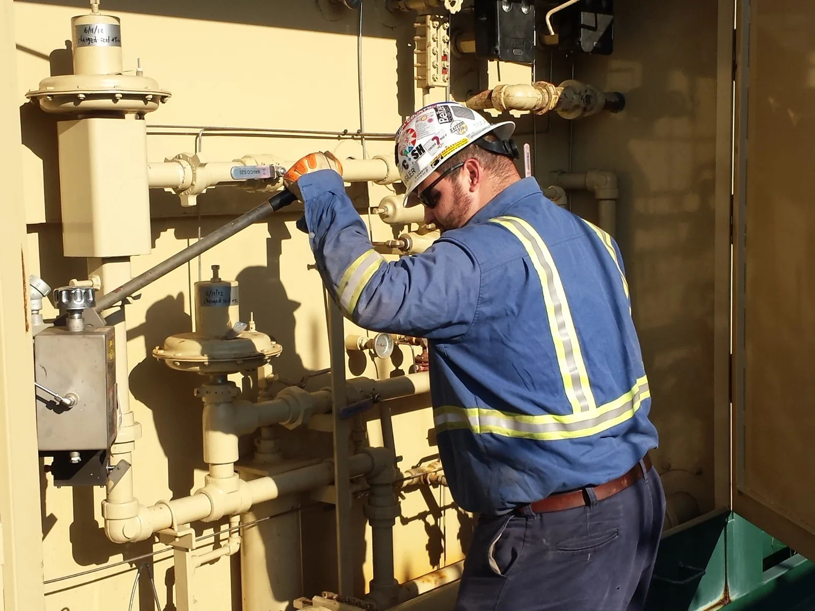 ShalePro lease operator checking a wellsite meter run